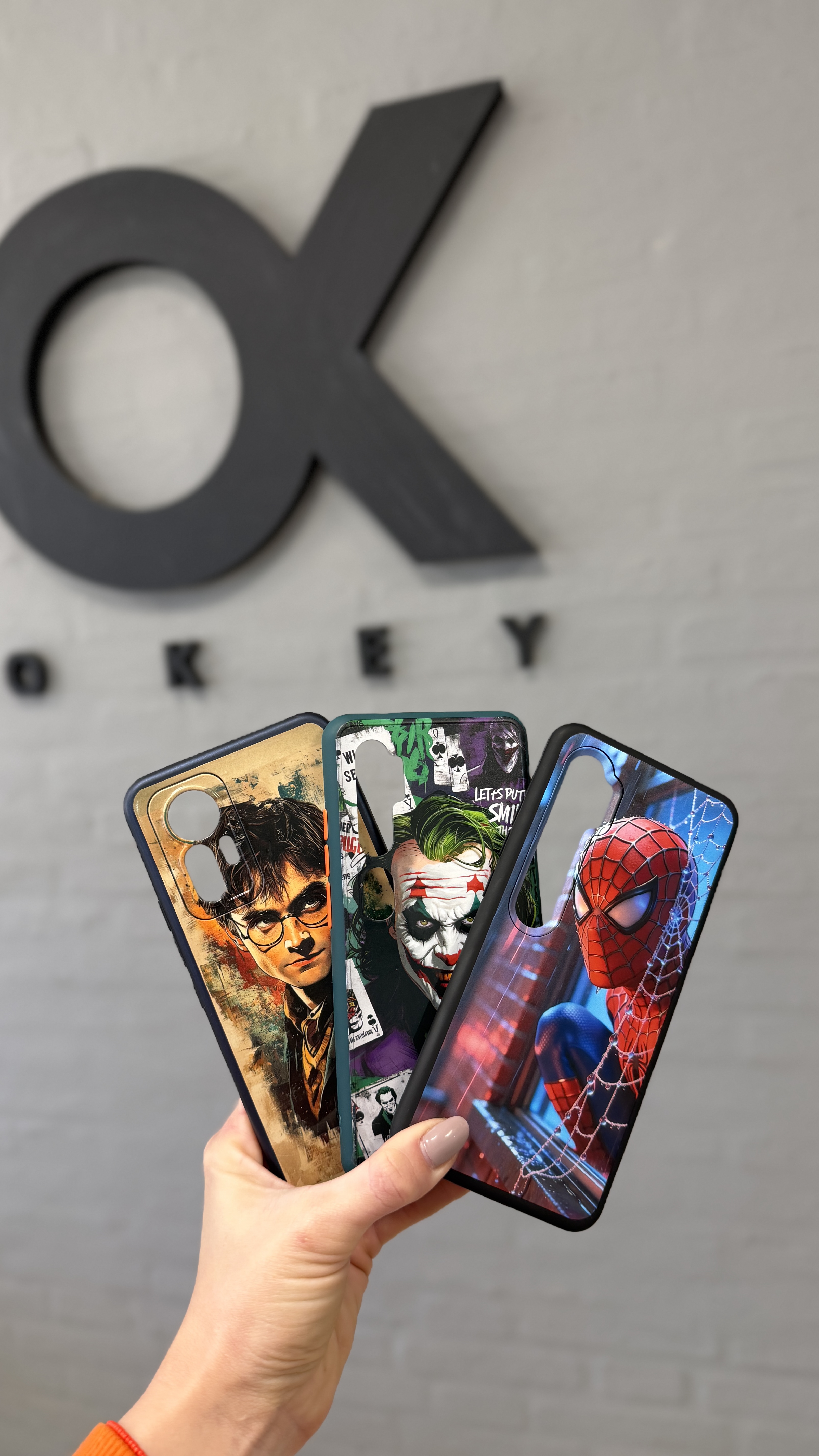 Tres fundas personalizadas mostradas frente al logo de Okey